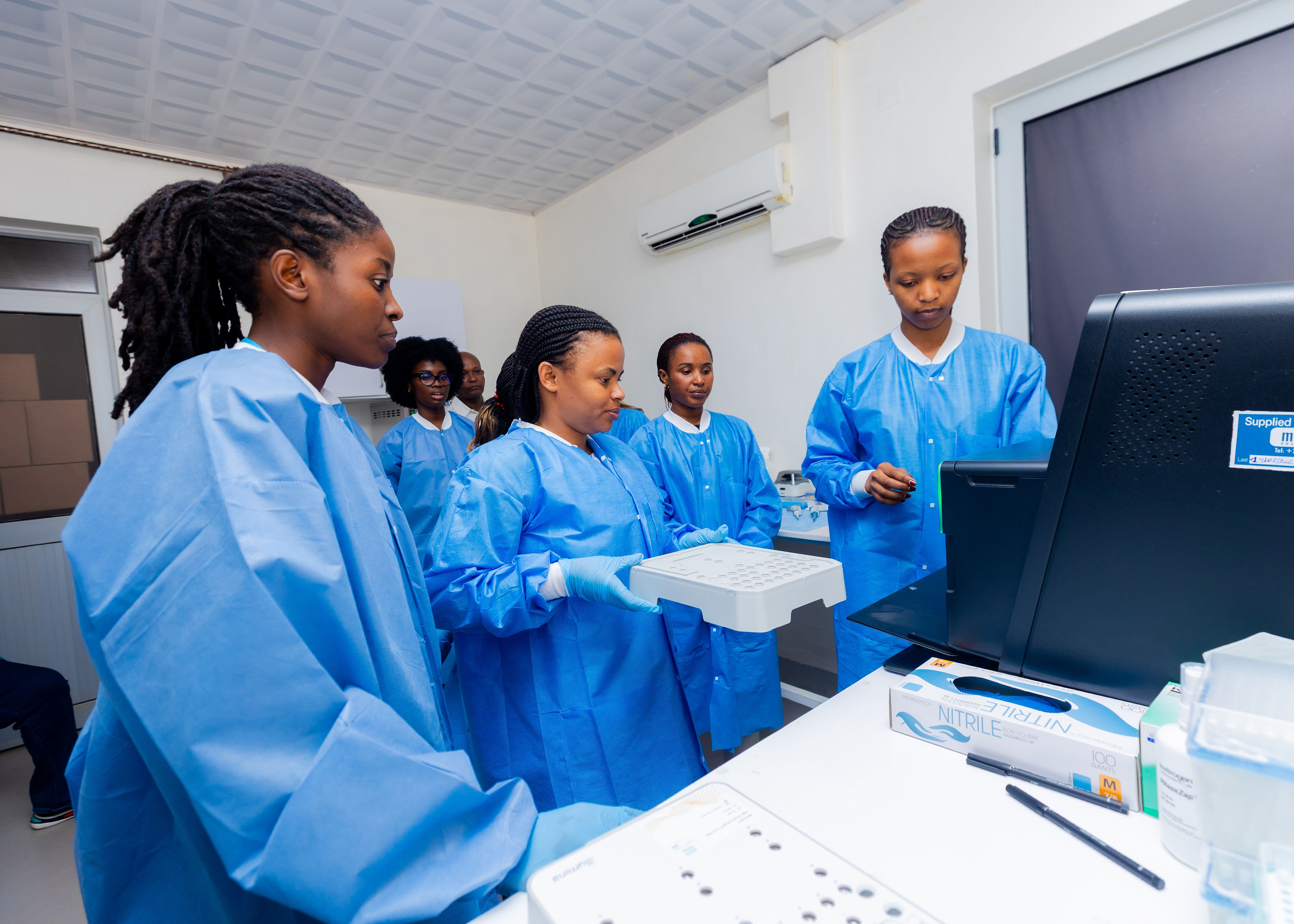 Scientists in a laboratory in Rwanda working with diagnostic equipment.