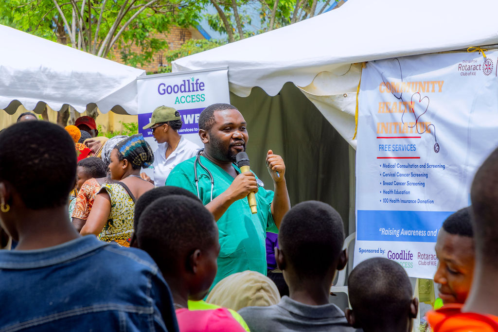 A Goodlife clinician speaks to a crowd at a community health screening event.