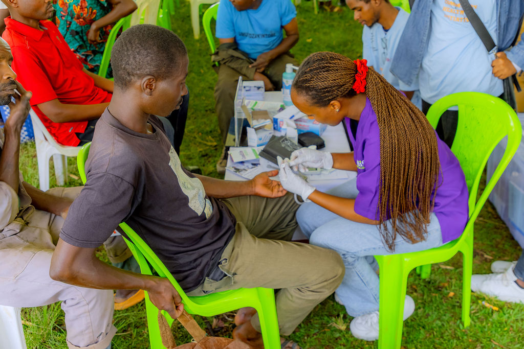 A Goodlife health worker takes a blood sample during a community screening.